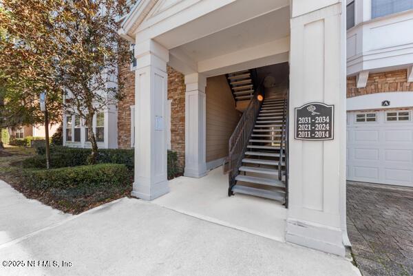 view of exterior entry featuring a garage and stone siding