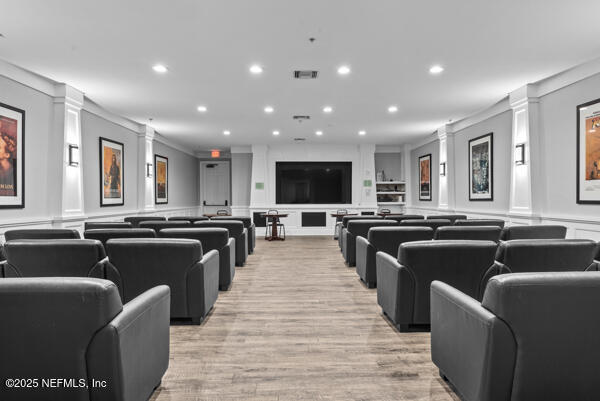 cinema with decorative columns, ornamental molding, a decorative wall, and recessed lighting