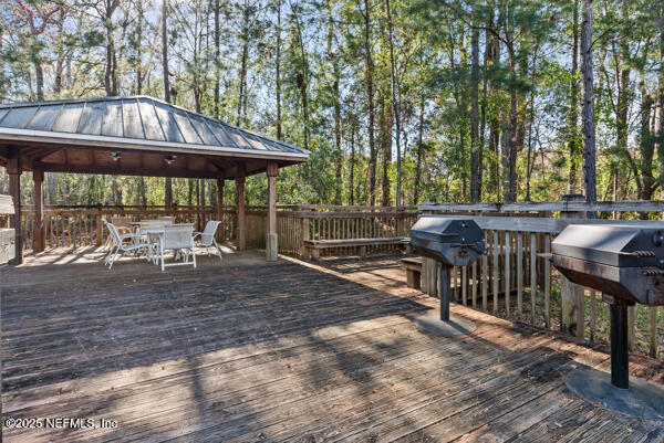 wooden deck with a gazebo and outdoor dining area