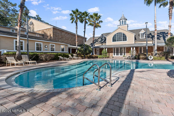 pool with french doors and a patio