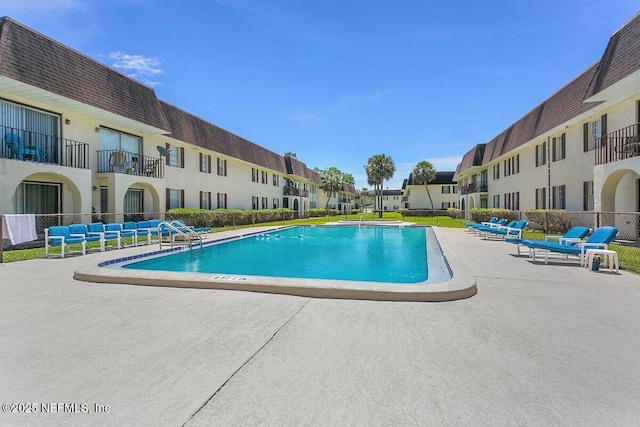 pool with a patio area and a residential view