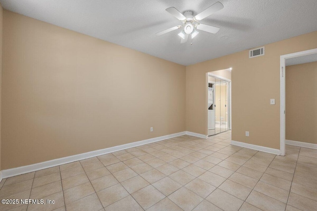 unfurnished room with light tile patterned floors, baseboards, visible vents, ceiling fan, and a textured ceiling