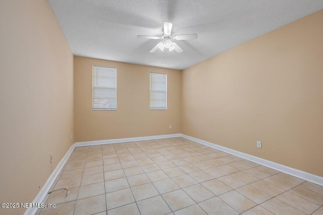 empty room featuring ceiling fan, a textured ceiling, and baseboards