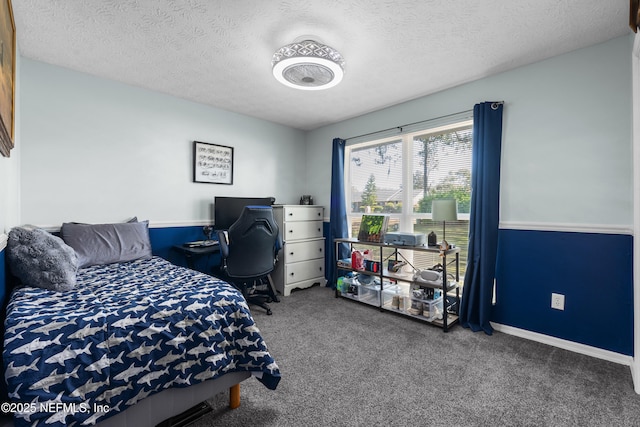 bedroom featuring a textured ceiling, carpet, and baseboards