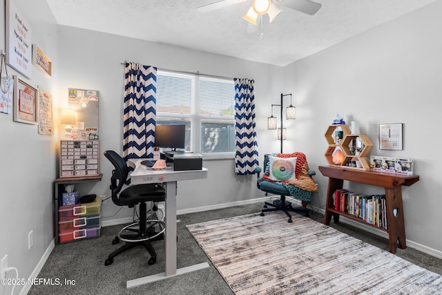 carpeted office space featuring a textured ceiling, a ceiling fan, and baseboards