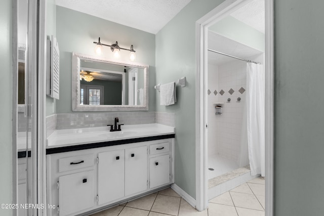 full bath featuring tasteful backsplash, a tile shower, vanity, a textured ceiling, and tile patterned floors