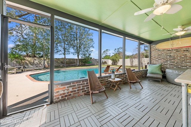 unfurnished sunroom featuring ceiling fan