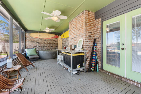 unfurnished sunroom featuring ceiling fan and a wealth of natural light