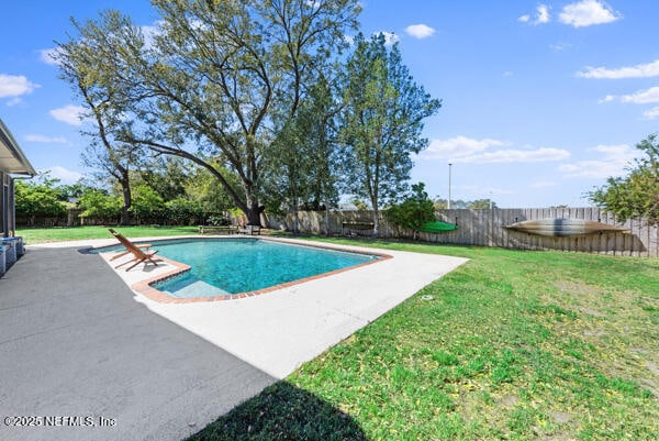 view of swimming pool featuring a yard, a patio area, a fenced backyard, and a fenced in pool