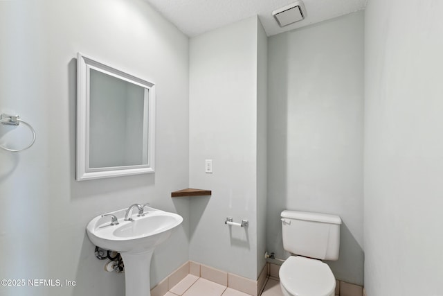 half bathroom with visible vents, baseboards, toilet, and tile patterned flooring