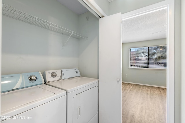 clothes washing area with light wood-type flooring, baseboards, laundry area, and washing machine and clothes dryer