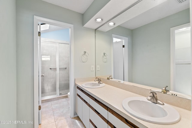 bathroom featuring tile patterned flooring, a shower stall, double vanity, and a sink