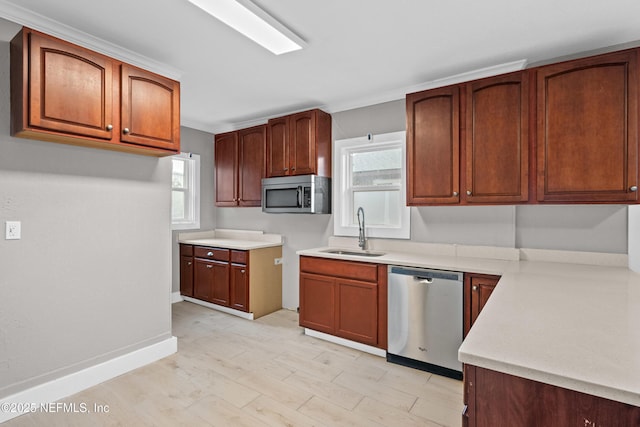 kitchen featuring baseboards, light wood-style flooring, stainless steel appliances, light countertops, and a sink