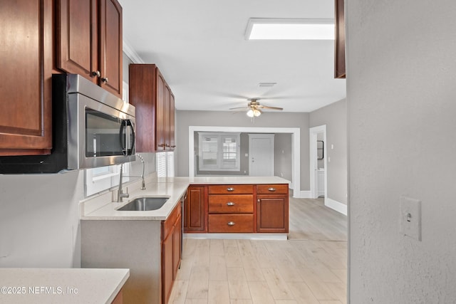 kitchen featuring light countertops, stainless steel microwave, and a sink