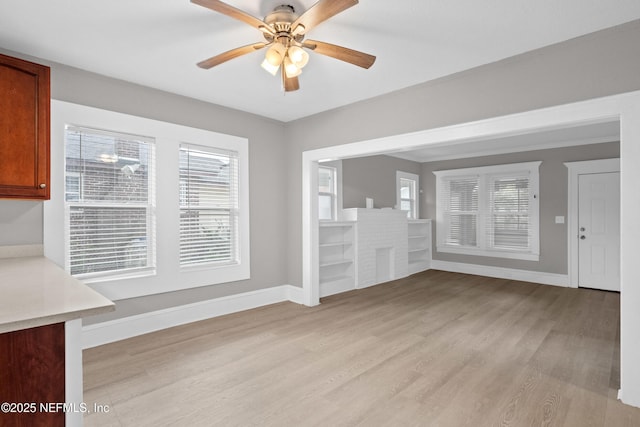 unfurnished dining area featuring light wood-style floors, baseboards, and a ceiling fan