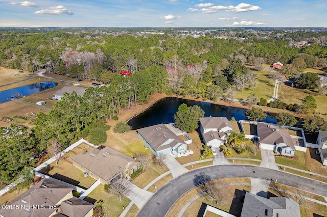 birds eye view of property with a forest view, a residential view, and a water view