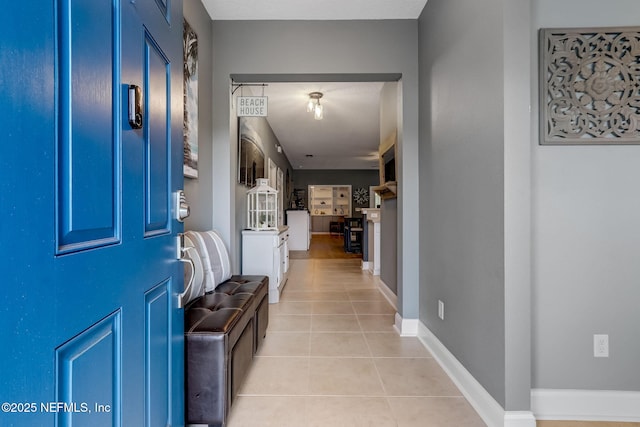 foyer entrance with light tile patterned floors and baseboards