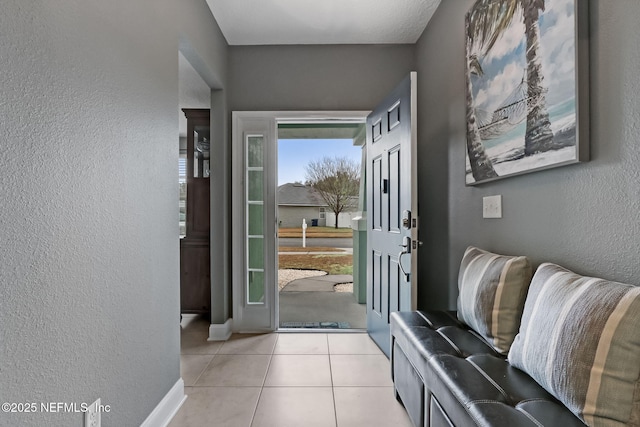 doorway featuring light tile patterned flooring and a textured wall