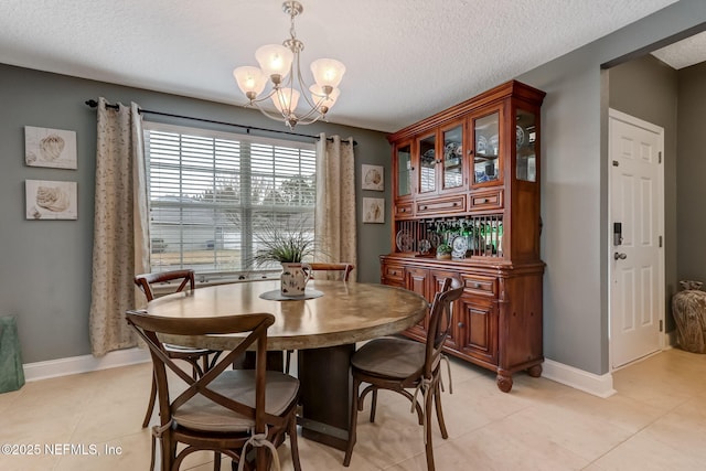 dining room featuring light tile patterned flooring, a notable chandelier, and baseboards