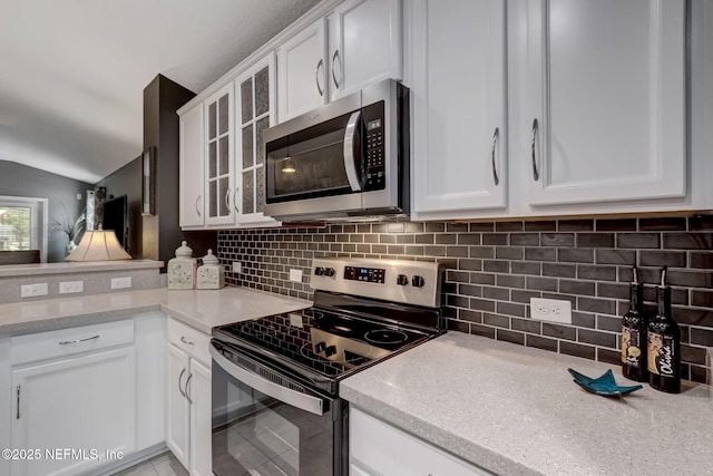 kitchen featuring white cabinetry, backsplash, glass insert cabinets, and appliances with stainless steel finishes