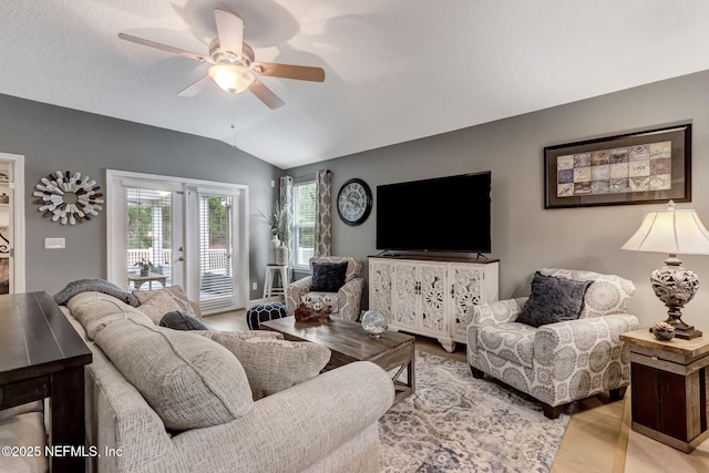 living area featuring light wood-style floors, ceiling fan, and vaulted ceiling