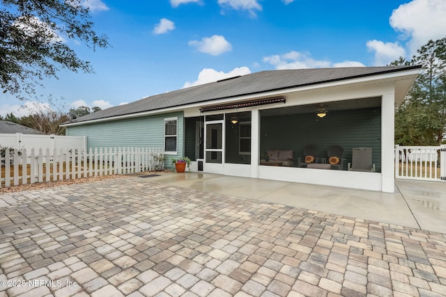 back of house featuring fence private yard, a ceiling fan, and a sunroom