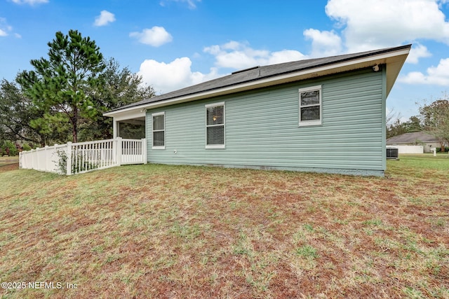 back of property with a yard and fence