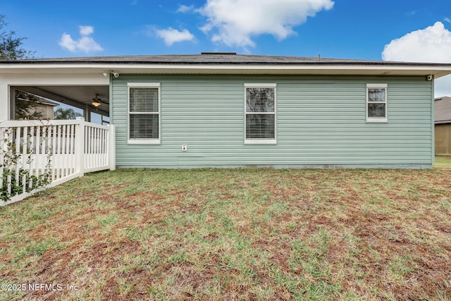 view of property exterior with a yard and a ceiling fan