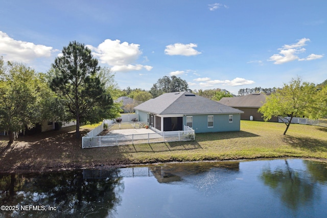 back of property featuring a water view, a lawn, a fenced backyard, driveway, and a patio