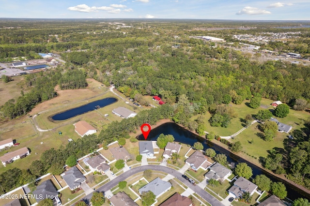 birds eye view of property featuring a residential view, a wooded view, and a water view