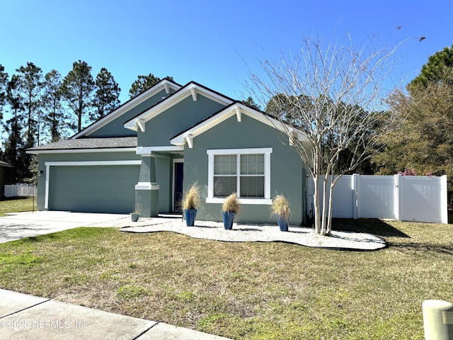 view of front facade featuring stucco siding, an attached garage, driveway, and a gate