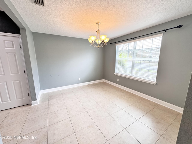 unfurnished room featuring visible vents, baseboards, a textured ceiling, and a chandelier