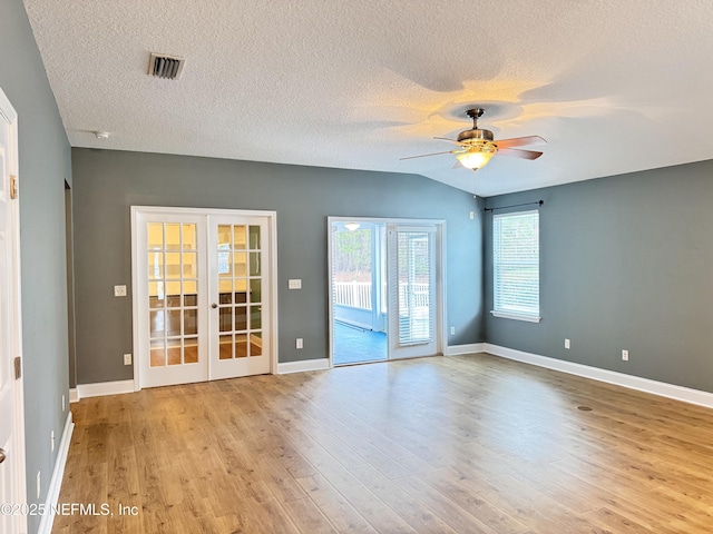 unfurnished room featuring a ceiling fan, visible vents, baseboards, light wood-style flooring, and french doors