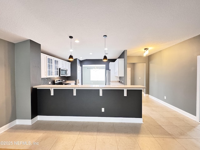 kitchen featuring a peninsula, a breakfast bar area, and stainless steel appliances