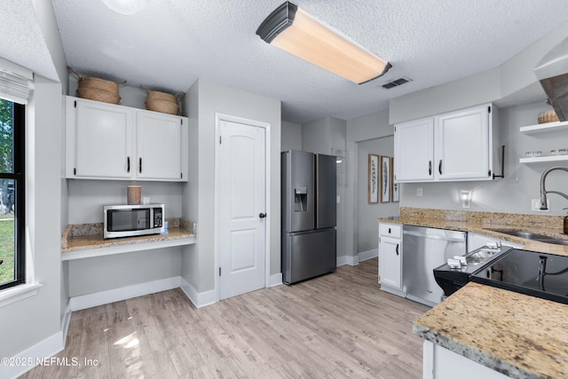 kitchen featuring visible vents, built in study area, stainless steel appliances, open shelves, and a sink