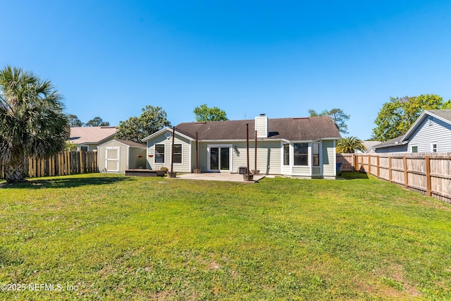 rear view of property featuring a patio area, a shed, a fenced backyard, and an outdoor structure