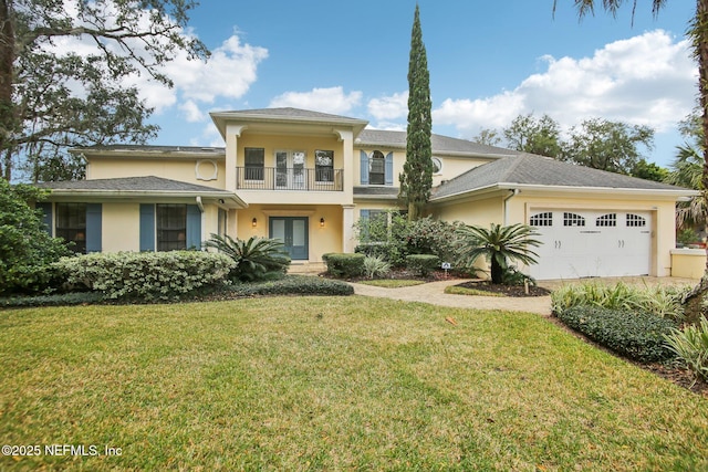 view of front facade with a balcony, a garage, french doors, stucco siding, and a front yard