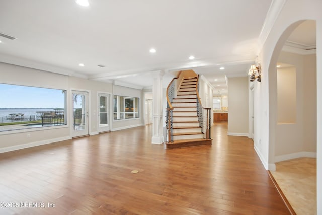 interior space with ornamental molding, light wood-type flooring, visible vents, and recessed lighting