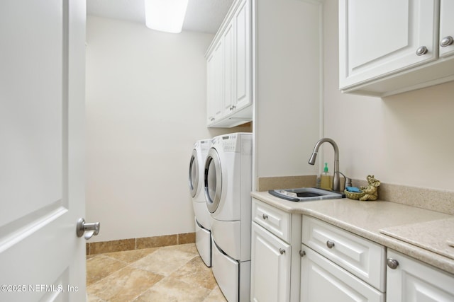 laundry area featuring cabinet space, baseboards, washer and clothes dryer, and a sink