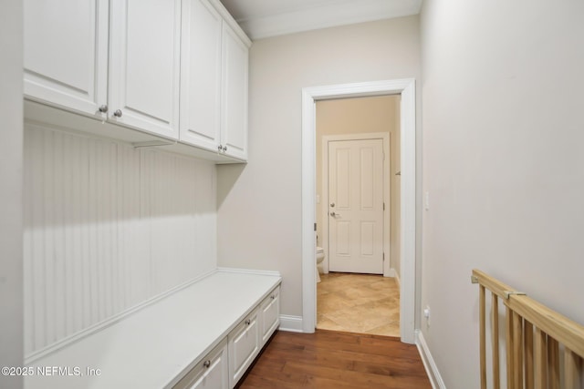 mudroom with dark wood-type flooring and baseboards