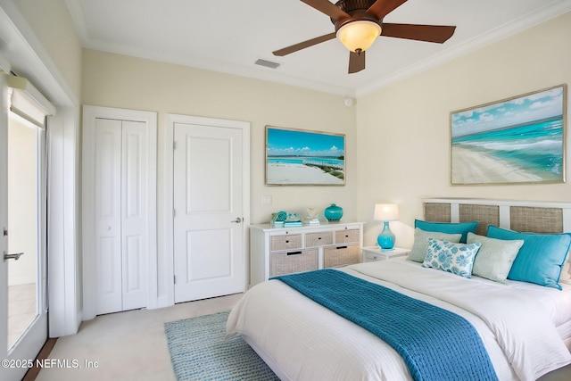 bedroom with crown molding, a ceiling fan, visible vents, and light colored carpet