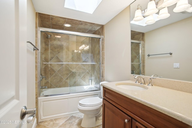 full bathroom featuring a skylight, shower / bath combination with glass door, vanity, and toilet