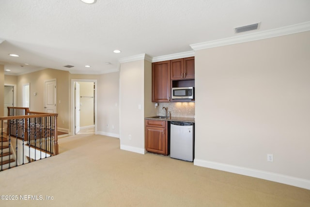 kitchen featuring tasteful backsplash, visible vents, dishwasher, stainless steel microwave, and a sink