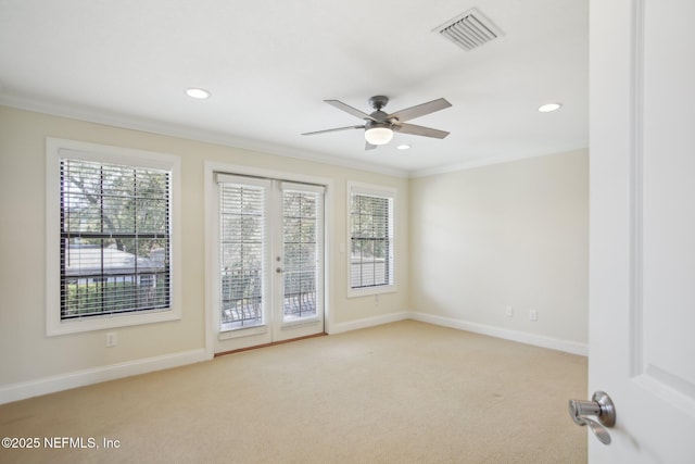 unfurnished room featuring french doors, visible vents, ornamental molding, light carpet, and baseboards