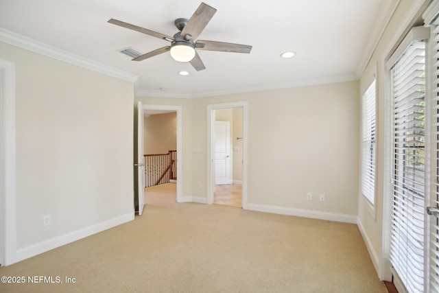 unfurnished bedroom with visible vents, ornamental molding, baseboards, and light colored carpet