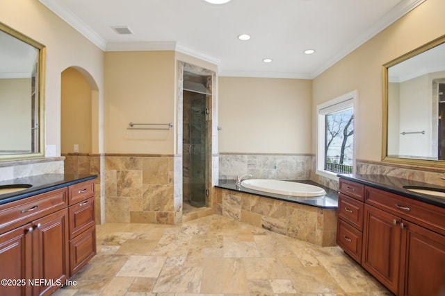 bathroom featuring a bath, a shower stall, visible vents, and crown molding