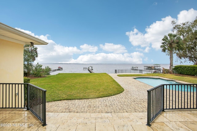 exterior space with a water view, a patio area, a fenced in pool, and a yard