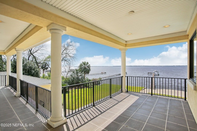 view of patio featuring a water view and a balcony