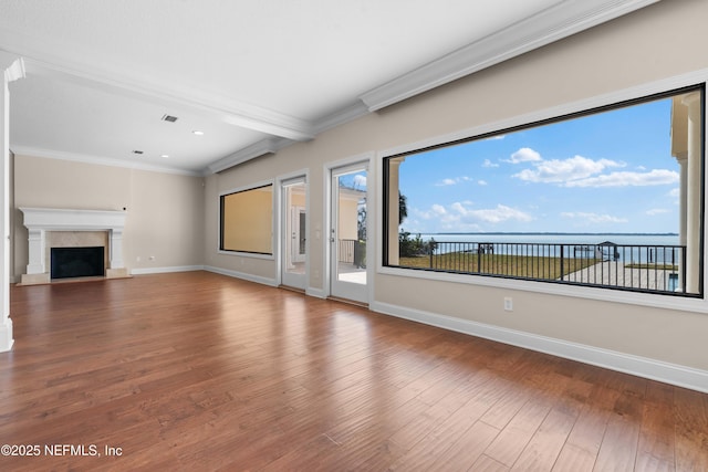 unfurnished living room featuring ornamental molding, baseboards, and wood finished floors