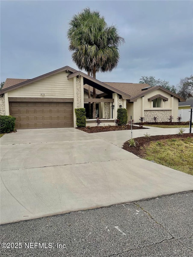 view of front of property with driveway, an attached garage, and stucco siding